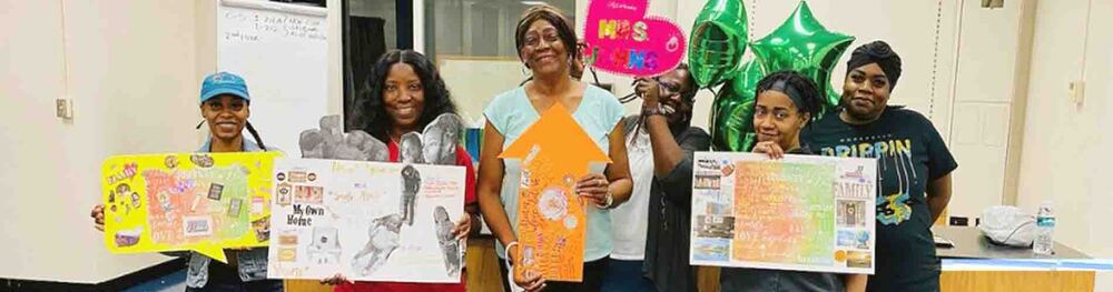 Group of Family Self-Sufficiency (FSS) people holding vision boards.