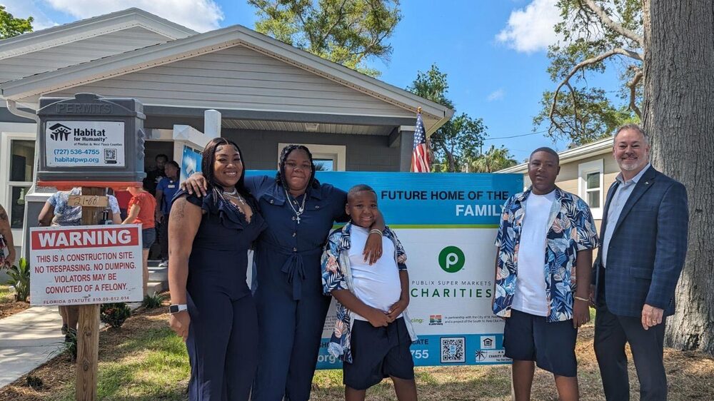 FSS participant and her three kids in front of new house.