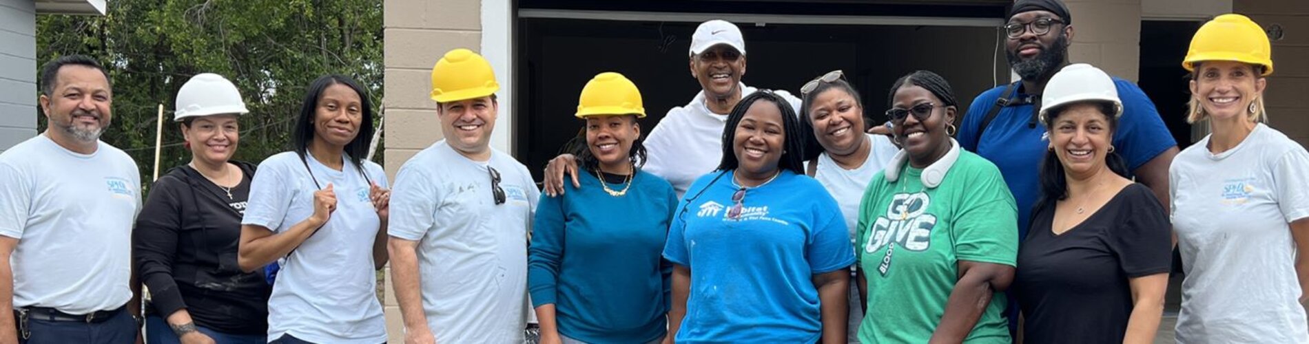 A group of individuals with hard hats posing for a group photo.