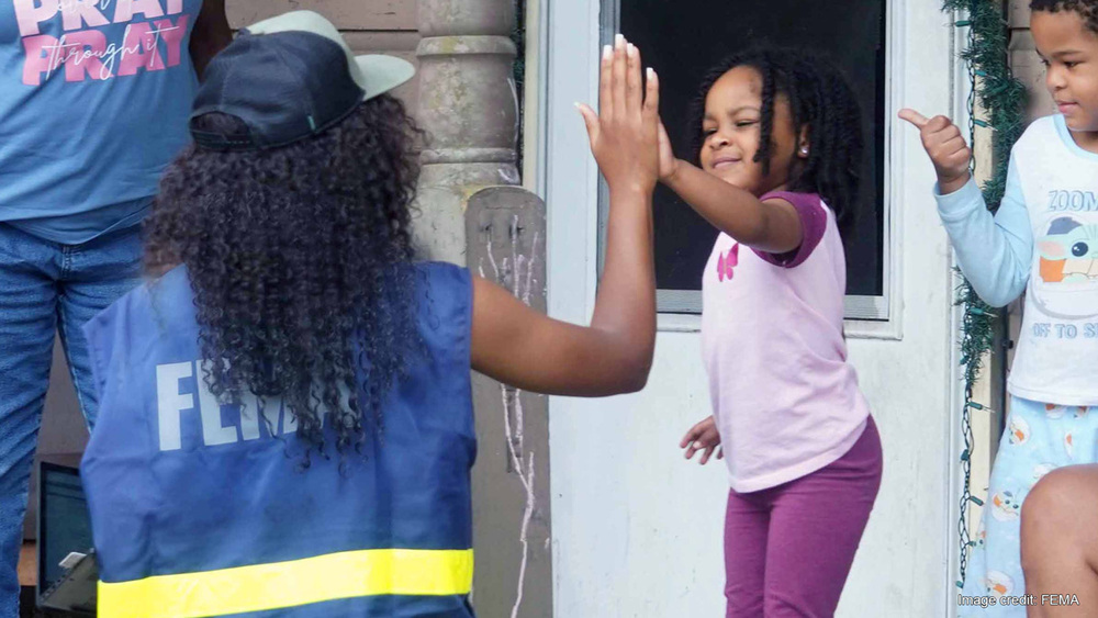 FEMA official helping a family.