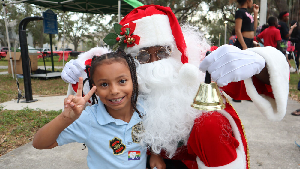 Child and Santa Claus at Very Merry Holiday Party in Jordan Park.