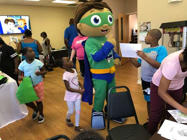 Wyatt Beanstalk from Super Why interacting with a group of children.