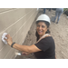 SPHA woman wearing white hat smiling and painting house.