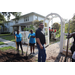 Two Habitat for Humanity volunteers holding shovels and a man wearing sunglasses at the Jordan Park Community Garden on August 8, 2024.