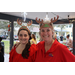 Two women wearing red shirts and reindeer antlers at Very Merry Holiday Party in Jordan Park.