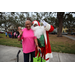 Woman in pink shirt and Santa Claus waving at Very Merry Holiday Party in Jordan Park.