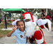 Child wearing light blue shirt with Santa Claus at Very Merry Holiday Party in Jordan Park.