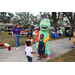 Great Explorations Children's Museum dinosaur mascot at Very Merry Holiday Party in Jordan Park.