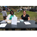 Two woman smiling and seated at table at Very Merry Holiday Party in Jordan Park.